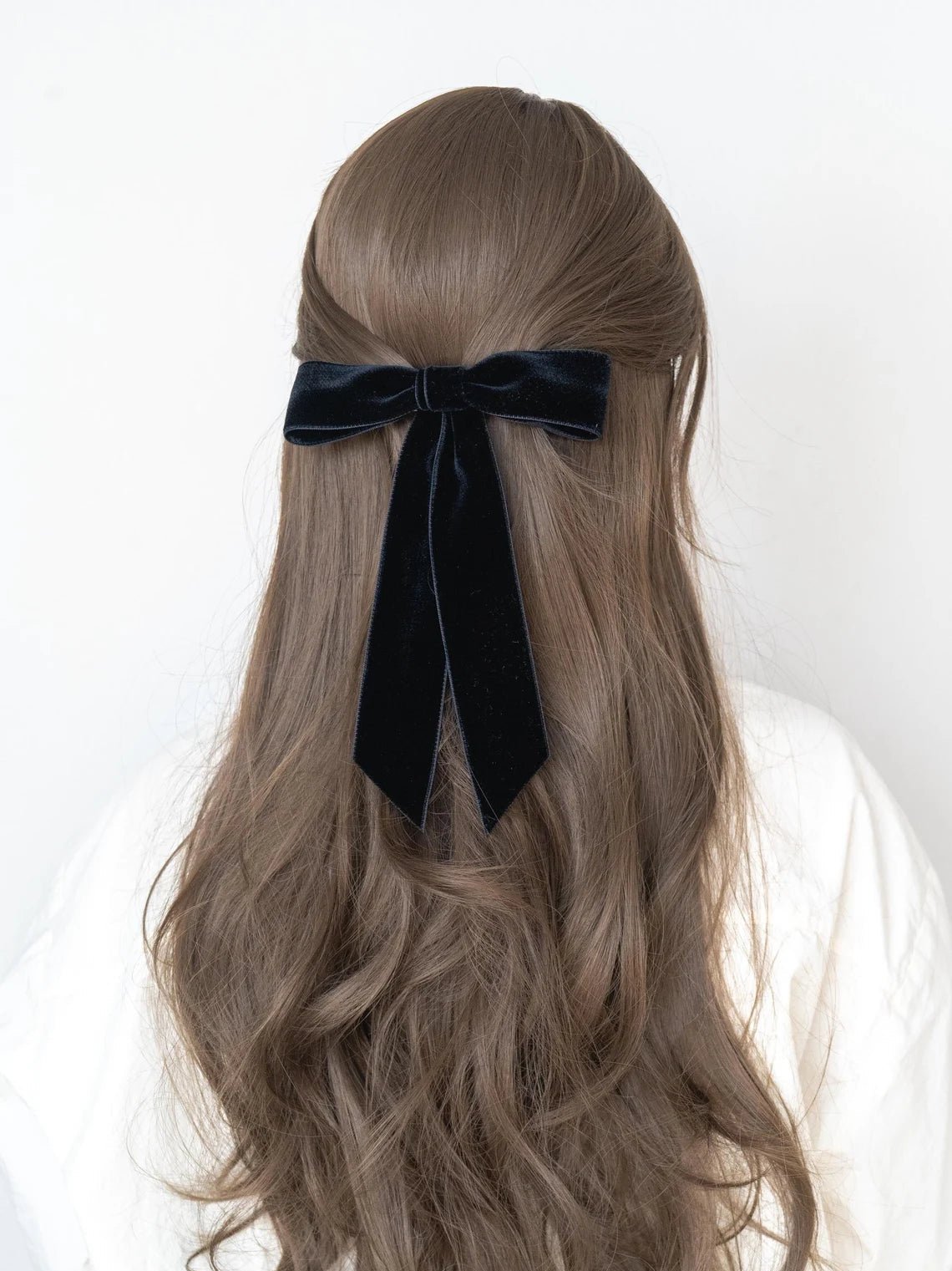 Long wavy hair with a black velvet ribbon on a white background